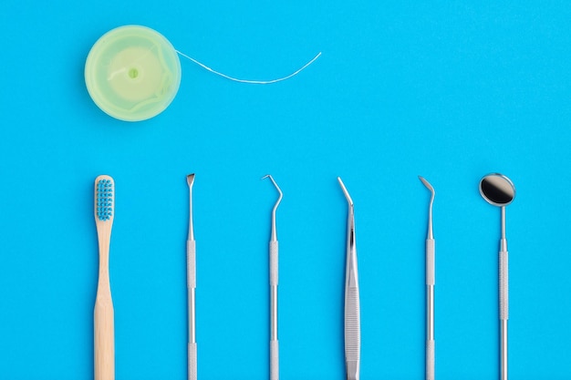 Outils de dentiste sur la vue de dessus de fond bleu