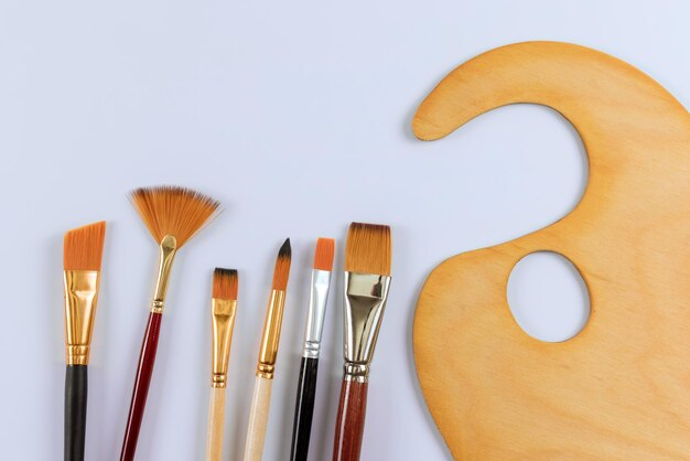 Outils de dessin avec pinceaux d'artiste peintre et palette de peinture sur fond blanc isolé