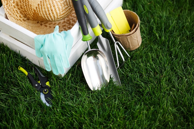 Outils de jardinage et chapeau de paille sur l'herbe dans le jardin.