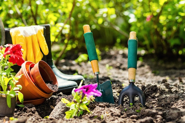 Outils de jardinage et fleurs dans le jardin tels que arrosoir bottes en caoutchouc vases pots gants en caoutchouc
