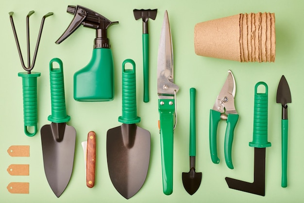 Photo outils de jardinage sur fond vert mise à plat