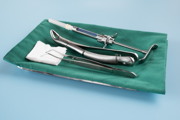 Photo outils médicaux de dentisterie forcept sur fond bleu.