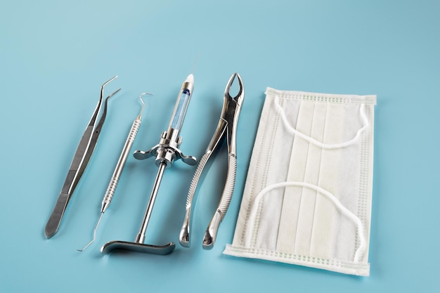 Les outils médicaux de dentisterie forcept supérieur/inférieur sur fond bleu.