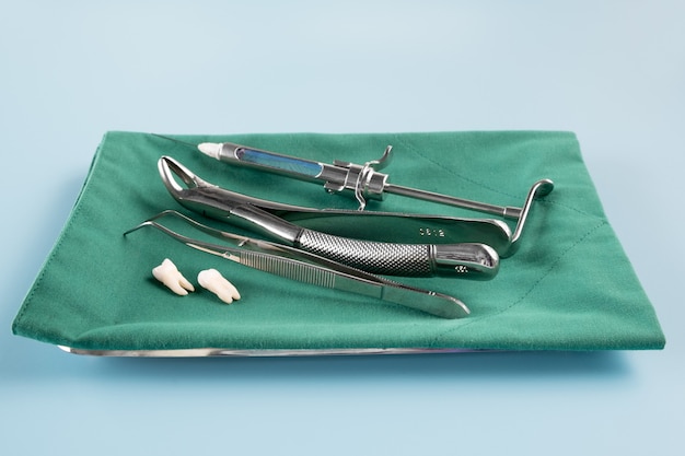 Outils médicaux de dentisterie forcept sur surface bleue