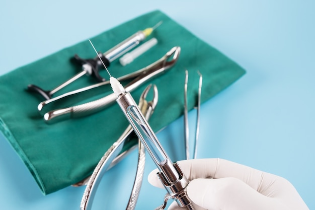 Photo outils médicaux de dentisterie seringue sur fond bleu.