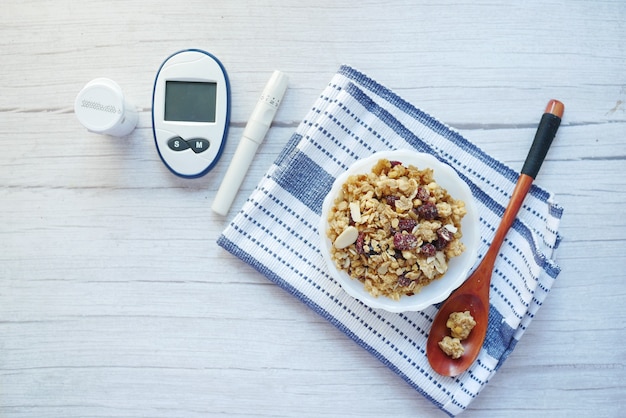 outils de mesure du diabète et céréales de petit déjeuner dans un bol sur table