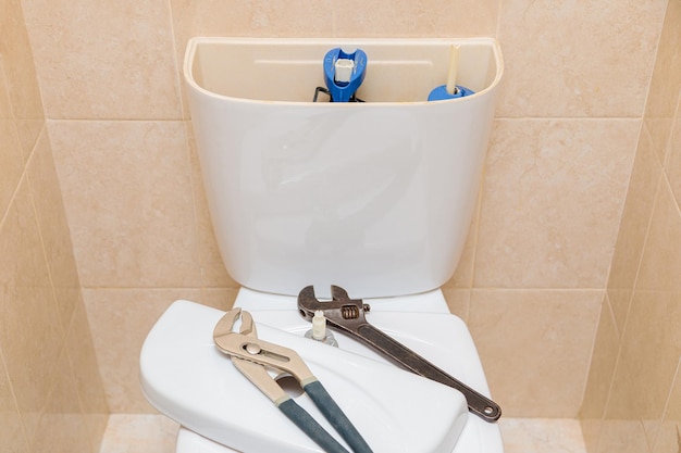 Outils de plomberie dans les toilettes sur un bol de toilette blanc