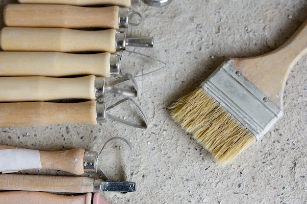 Outils pour créer un bas-relief et un pinceau sur un fond de béton