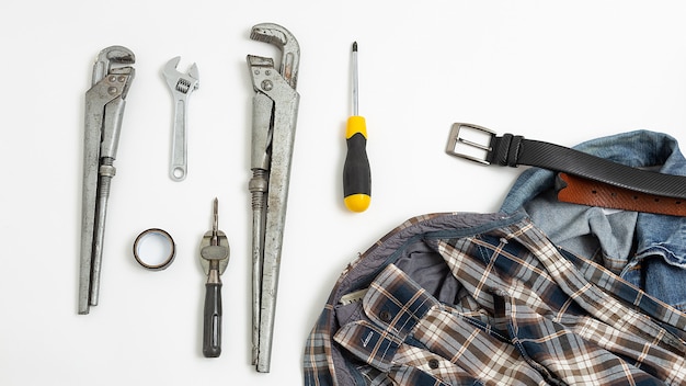 Outils près de chemise à carreaux, jeans, vue de dessus de ceinture en cuir. passe-temps pour hommes