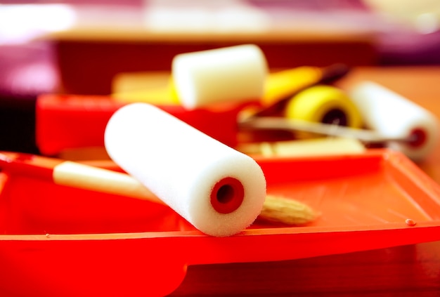 Outils de réparation à domicile. Rouleaux en mousse pour la coloration des murs dans un récipient en plastique se bouchent.