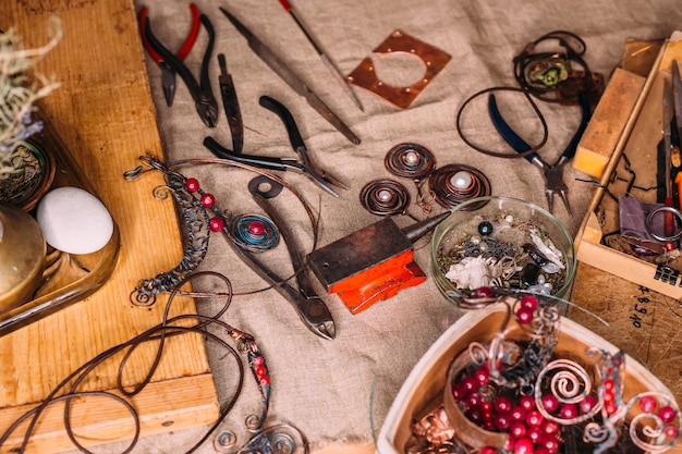 Outils de travail à la main en fil de cuivre sur la table avec accessoires. concept d'art des gens de l'artisanat