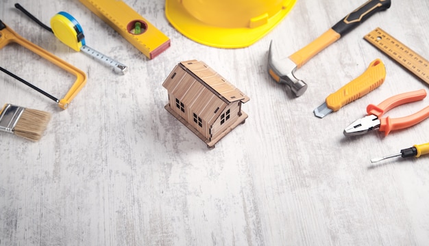 Outils de travail avec un modèle de maison en bois