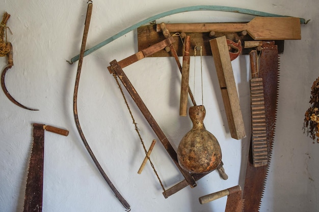 Outils vintage sur le mur Scies, faucilles et autres instruments vintage