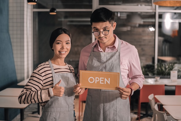 Ouverture de la cafétéria. Couple d'entrepreneurs prometteurs ouvrant leur propre petite cafétéria confortable