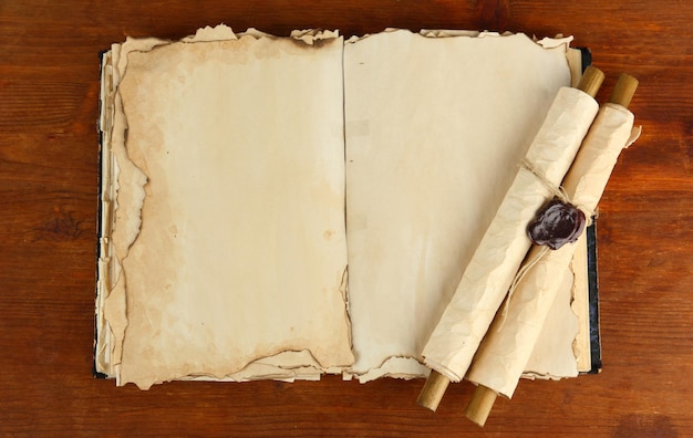 Ouverture de vieux livres et rouleaux sur fond de bois