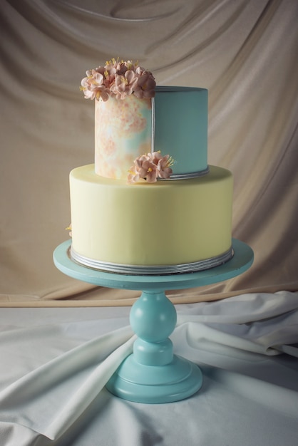 Ouvrages d'art. Gâteau de mariage décoré dans un style pastel avec des fleurs roses