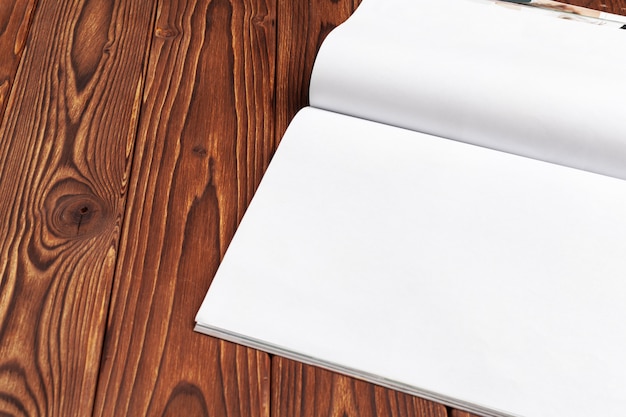 Ouvrez des pages de journal vierges pour votre espace de copie de conception sur fond en bois