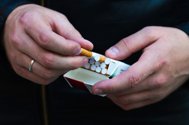 Ouvrez le paquet de cigarettes dans les mains des hommes