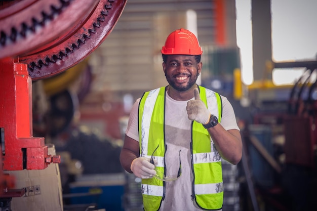 Ouvrier américain travaillant dans l'usineUn homme noir américain africain est un opérateur industriel de l'usine de machines de contrôle