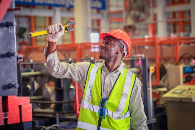 Ouvrier américain travaillant dans l'usineUn homme noir américain africain est un opérateur industriel de l'usine de machines de contrôle