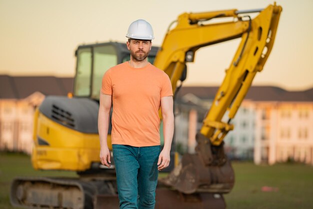 Ouvrier au constructeur du chantier de construction dans l'homme de construction de casque avec casque travailleur à la construction w