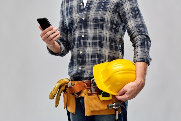 ouvrier ou bâtisseur avec téléphone et outils de travail