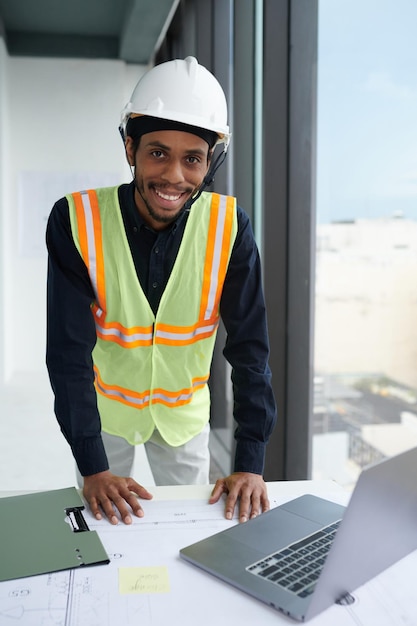 Un ouvrier de la construction souriant dans un chapeau dur