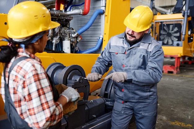 Ouvrier contemporain d'usine consultant jeune femme subordonnée