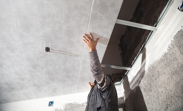 Ouvrier du bâtiment assembler un plafond suspendu