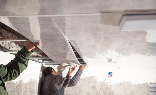 Ouvrier du bâtiment assembler un plafond suspendu