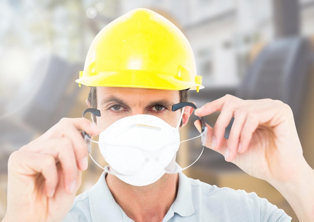 Photo ouvrier du bâtiment avec masque devant le chantier de construction