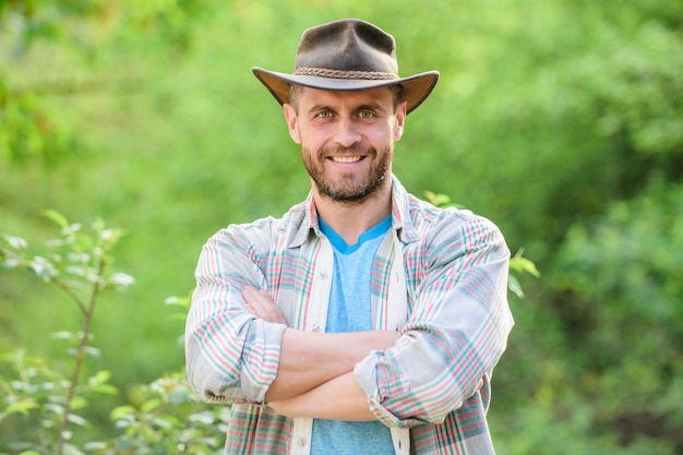 Ouvrier éco-agricole. Récolte. l'agriculture et la culture agricole. Ranch de jardinage. joyeux Jour de la Terre. Éco-vivre. homme de ranch musclé dans les usines de soins de chapeau de cowboy. agriculteur sexy réussi. Travailler avec les plantes.