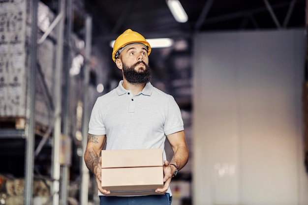 Un ouvrier d'entrepôt déplaçant une boîte et des marchandises