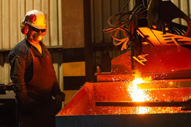 Ouvrier gérant une machine de découpe à oxycoupage CNC dans une usine