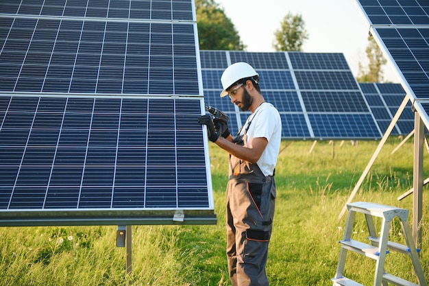 Un ouvrier indien travaille à l'installation de panneaux solaires dans un champ