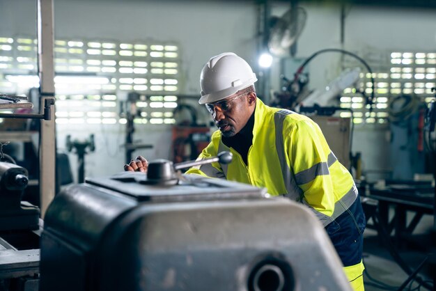 Photo ouvrier ou ingénieur d'usine fait un travail de machine dans un atelier de fabrication adepte