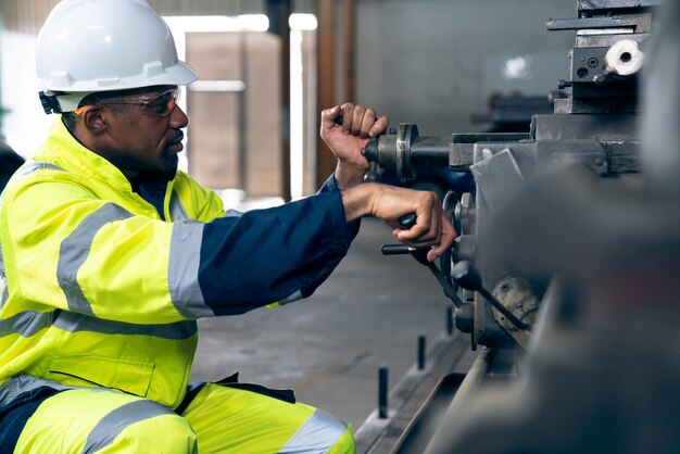 Ouvrier ou ingénieur d'usine fait un travail de machine dans un atelier de fabrication adepte