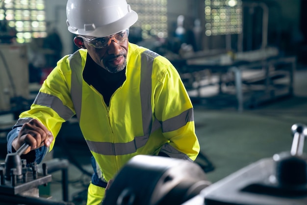 Ouvrier ou ingénieur d'usine fait un travail de machine dans un atelier de fabrication adepte