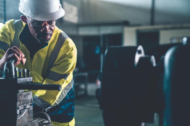 Ouvrier ou ingénieur d'usine fait un travail de machine dans un atelier de fabrication adepte