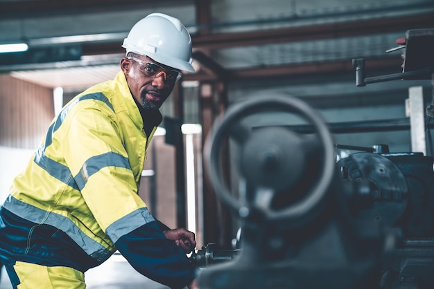 Ouvrier ou ingénieur d'usine fait un travail de machine dans un atelier de fabrication adepte