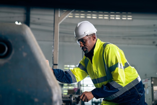 Ouvrier ou ingénieur d'usine fait un travail de machine dans un atelier de fabrication adepte