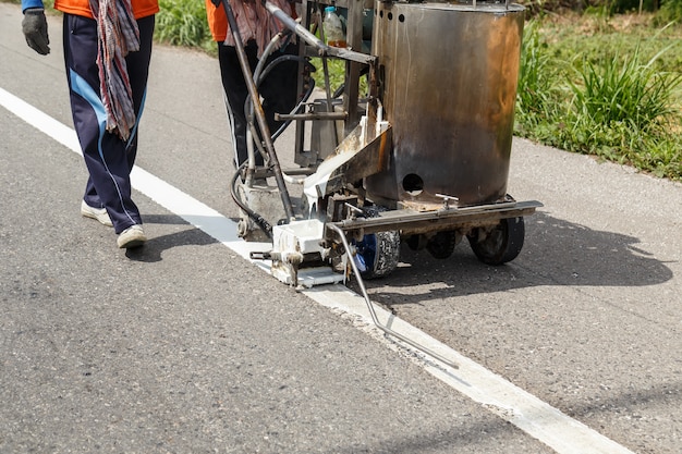 Ouvrier et machine de peinture travaillent dans la rue en Thaïlande