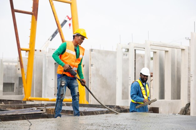 Photo ouvrier maçon asiatique versant le béton prêt à l'emploi dans une usine de murs en béton préfabriqués pour la fabrication de l'industrie lourde