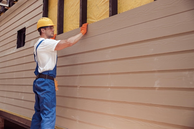 Ouvrier masculin construisant une maison sur un chantier de construction