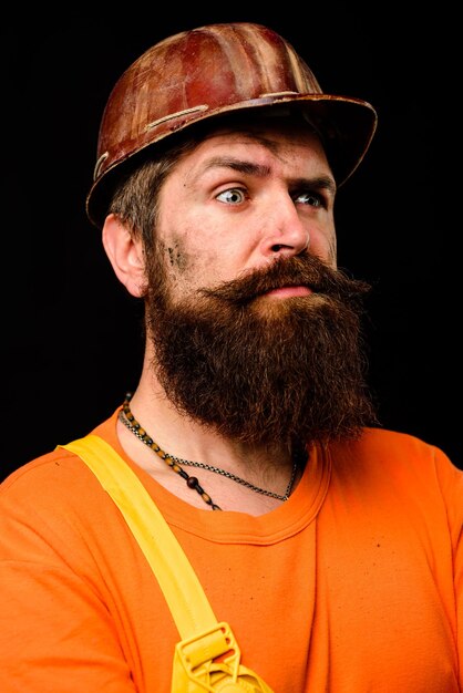 Ouvrier mécanique homme barbu en salopette et casque de construction ouvrier industriel construction