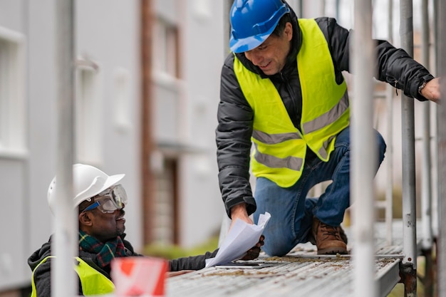 Photo un ouvrier montre un plan sur un chantier de construction