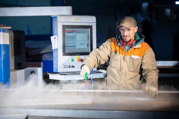 Un ouvrier de la production de meubles derrière une machine programmée fabrique des pièces de meubles. Fabrication de meubles.