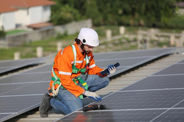 Ouvrier professionnel installant des panneaux solaires sur le toit d'une maison