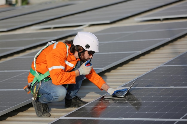 Ouvrier professionnel installant des panneaux solaires sur le toit d'une maison