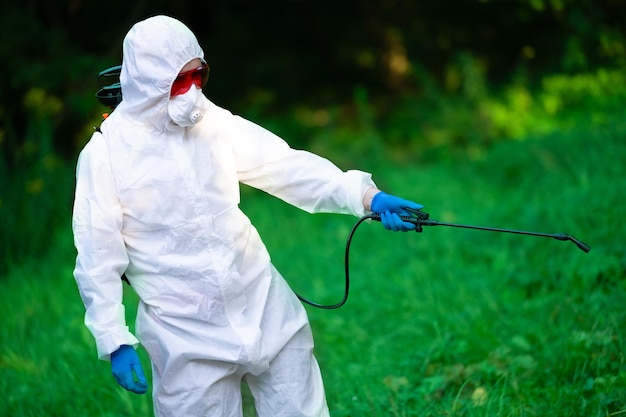 Un ouvrier pulvérise des pesticides sur les arbres à l'extérieur Contrôle des ravageurs des arbres Contrôle des parasites des insectes